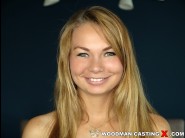 Kasandra layn is sited on a sofa, legs appart and looking at you