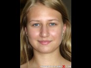 Milana blanc is sited on a sofa, legs appart and looking at you