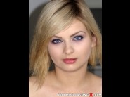 Angel black is sited on a sofa, legs appart and looking at you