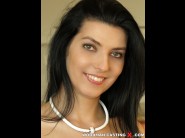 Bessie lowe is sited on a sofa, legs appart and looking at you