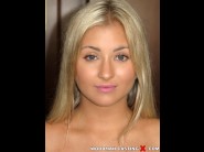 Cayla lyons is sited on a sofa, legs appart and looking at you