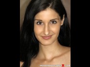 Coco kiss is sited on a sofa, legs appart and looking at you