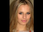 Jillian janson is sited on a sofa, legs appart and looking at you