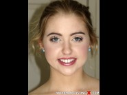 Chloe cherry is sited on a sofa, legs appart and looking at you