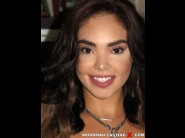 Selena santana is sited on a sofa, legs appart and looking at you