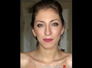 Milana cats is sited on a sofa, legs appart and looking at you