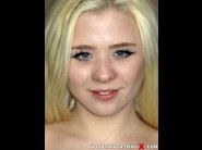 Anna rey is sited on a sofa, legs appart and looking at you