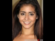 Aysha dama is sited on a sofa, legs appart and looking at you