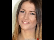 Ginger fox is sited on a sofa, legs appart and looking at you