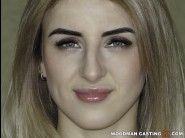 Lina adley is sited on a sofa, legs appart and looking at you